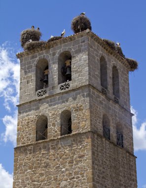 Church tower in Manzanares el Real with storks clipart