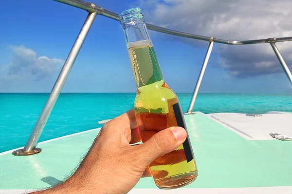 Beer on hand Caribbean in boat bow turquoise sea