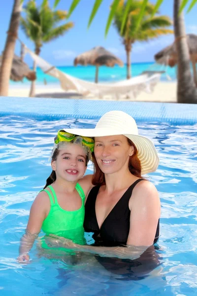Мать и дочь обнимаются в бассейне тропического пляжа — стоковое фото