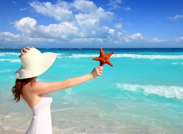在手热带加勒比海滩帽子的女人海星 — 图库照片