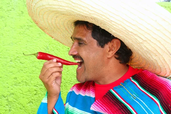 Σομπρέρο ΠΟΝΤΣΟ Μεξικού άνθρωπος τρώει κόκκινο καυτό τσίλι — Φωτογραφία Αρχείου