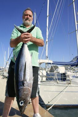 Elderly fisherman with Albacore tuna catch clipart
