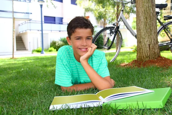 Boy teenager studying laying green grass garden — Stock Photo, Image