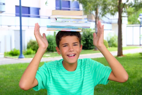 Chłopiec studentów nastolatek, trzymając głowę stos książek — Zdjęcie stockowe