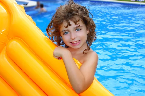 Beautiful little girl holding yellow pool float smiling — Stock Photo, Image