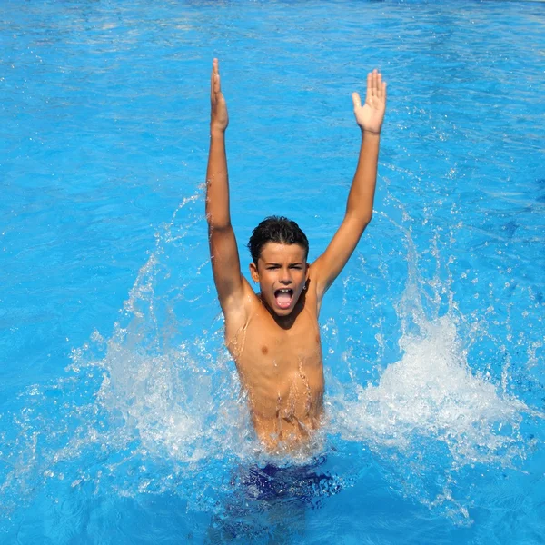 Niño adolescente salpicando agua abierta brazos piscina — Foto de Stock