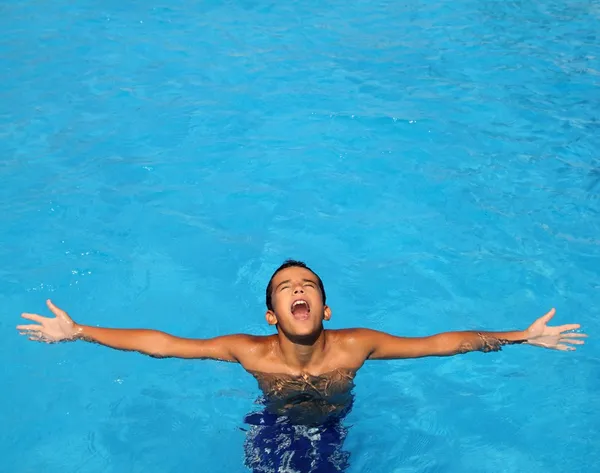 Pojke teenage avslappnad öppna armar blå poolen — Stockfoto