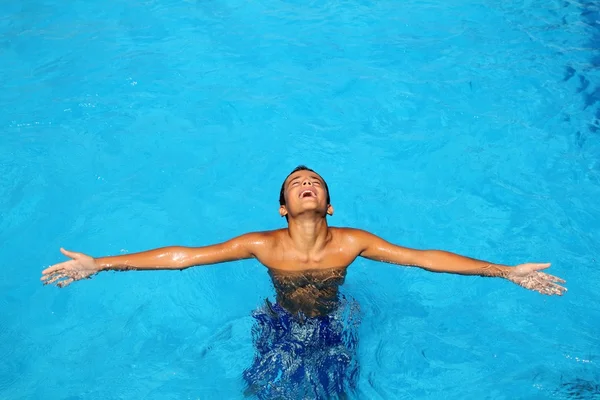 Boy teenage relaxed open arms blue swimming pool — Zdjęcie stockowe