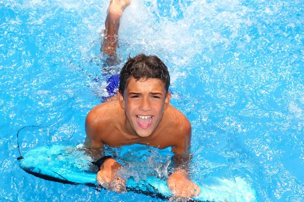 Dreng teenager surfbræt plaske blåt vand - Stock-foto