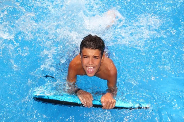 Boy teenager surfboard splashing blue water — Zdjęcie stockowe