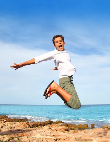 Boy teenager high fly jump on beach blue sky — Zdjęcie stockowe