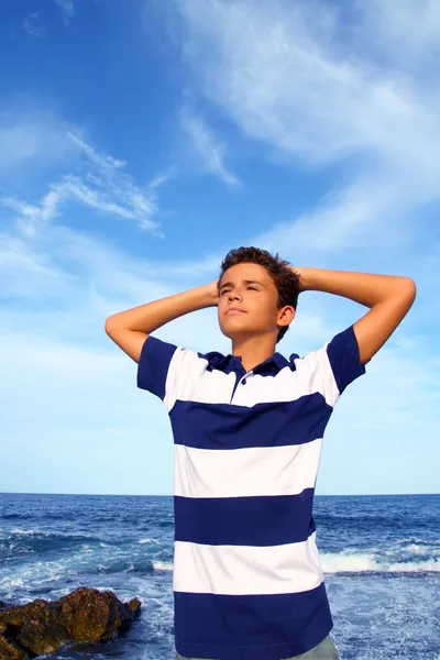Pojke tonåring händer i huvud avslappnad i blå havet — Stockfoto