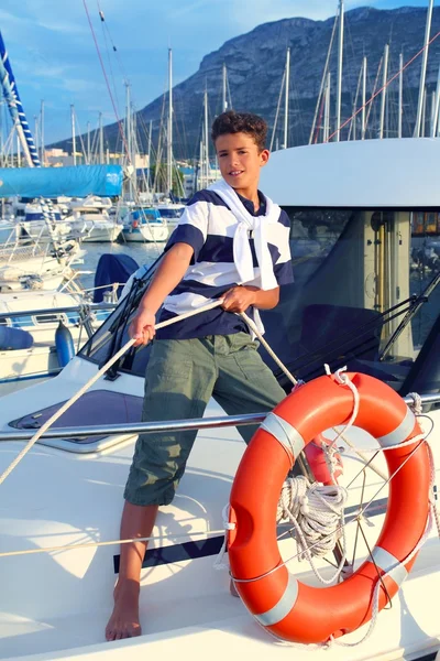 Хлопчик підліток моряк швартує човен мотузка в гавані — стокове фото
