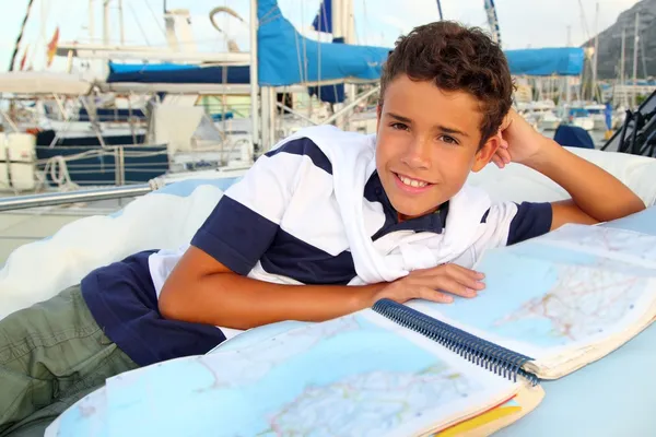 Boy teen sailor laying on marina boat chart map — Stock Photo, Image
