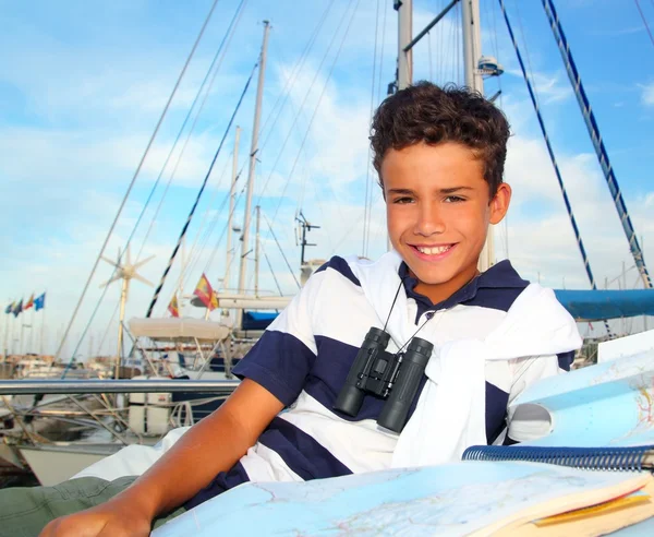 Мальчик-моряк, лежащий на карте яхт — стоковое фото