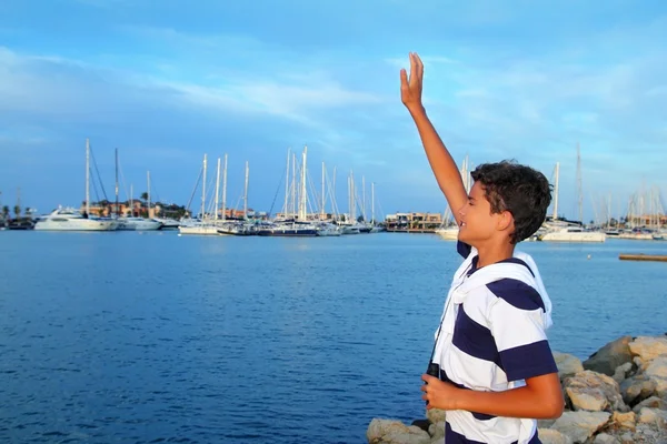 Farewell boy rising hand up goodbye in boats marina — Stock Photo, Image