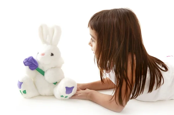 Morena niña jugando osito de peluche blanco — Foto de Stock