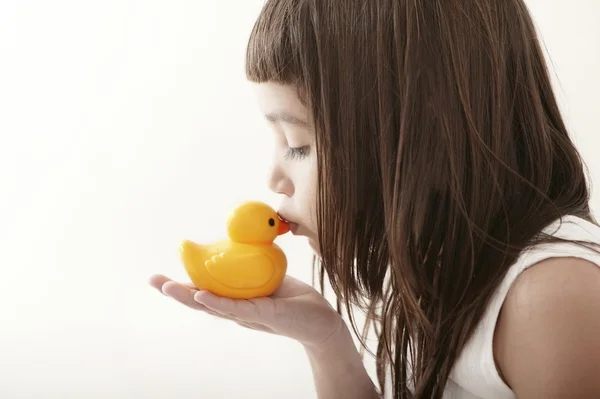 Kis kisgyermek lány csók a sárga fürdő a kacsa — Stock Fotó