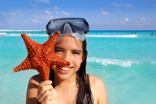 Latin tourist girl holding starfish tropical beach — Stock fotografie