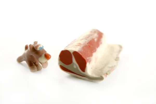 手作り空腹プラスチシン犬、肉を食べる — ストック写真