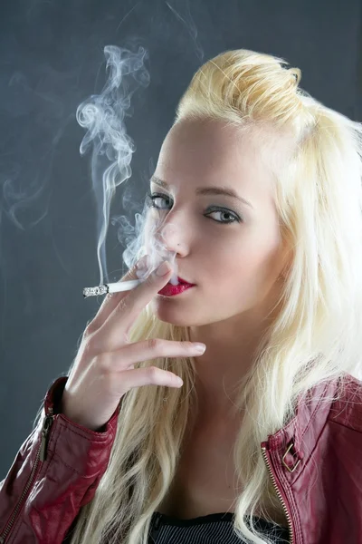Blonde smoking cigarette young fashion girl gray background — Stock Photo, Image