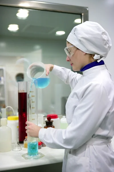 Kvinnan arbetar laboratorium, cylinder glasvas — Stockfoto