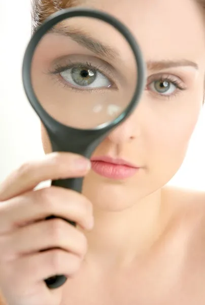 Woman with magnifier lens on eye — Stock Photo, Image