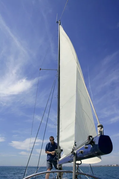 Мореплавець у вітрильному човні, що встановлює вітрила — стокове фото