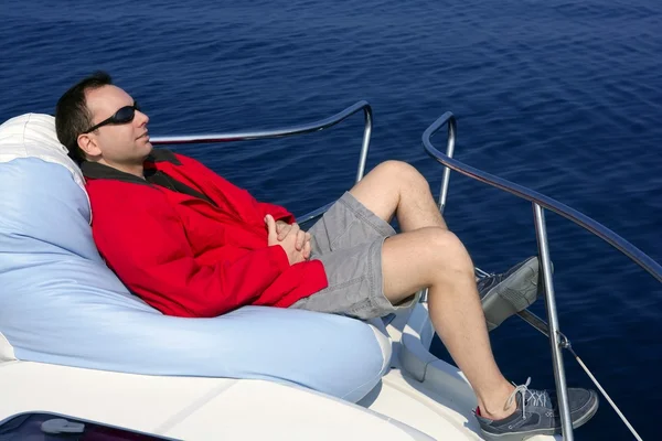 Человек на лодке расслабился на бобовом мешке — стоковое фото