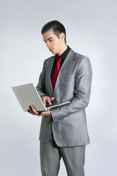 Empresário em terno cinza segurando laptop — Fotografia de Stock