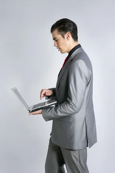 Бізнесмен в сірому костюмі тримає ноутбук — стокове фото