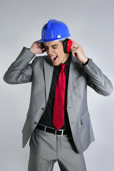 Бизнесмен в синей каске и наушниках безопасности — стоковое фото