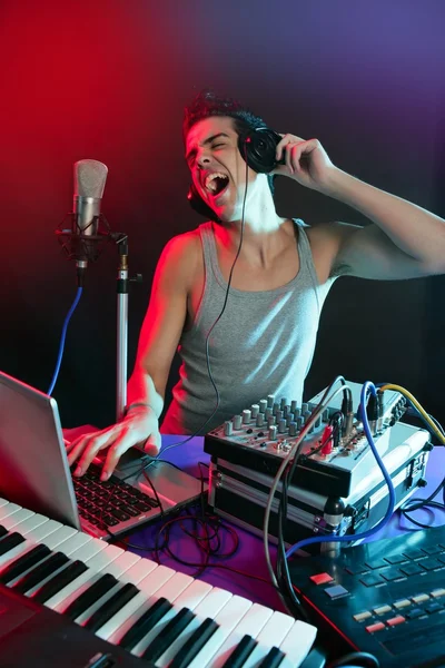 DJ met kleurrijke licht en muziek apparatuur mengen — Stockfoto