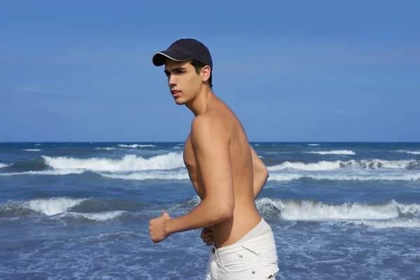 Bello giovanotto sulla spiaggia blu dell'oceano — Foto Stock