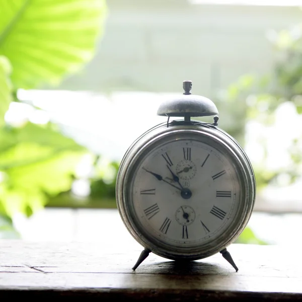 Antiguo reloj de alarma en la ventana retroiluminada — Foto de Stock