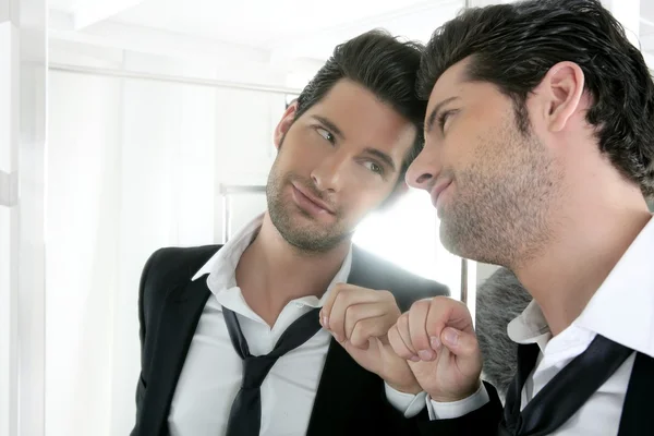 Jovem narcisista bonito olhando em um espelho — Fotografia de Stock