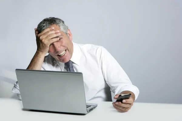 Laughing senior businessman computer phone gesture — Stock Photo, Image