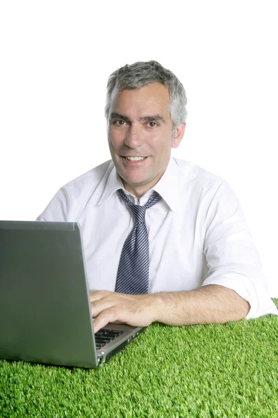 Zufriedener Senior-Geschäftsmann arbeitet im grünen Gras — Stockfoto