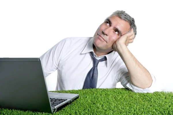 Бізнесмен старший розслаблений на зеленій траві столу — стокове фото