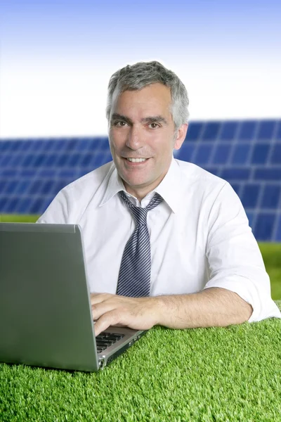 Ανώτερος επιχειρηματίας λειτουργεί πράσινο γρασίδι ηλιακή πλάκες — Φωτογραφία Αρχείου