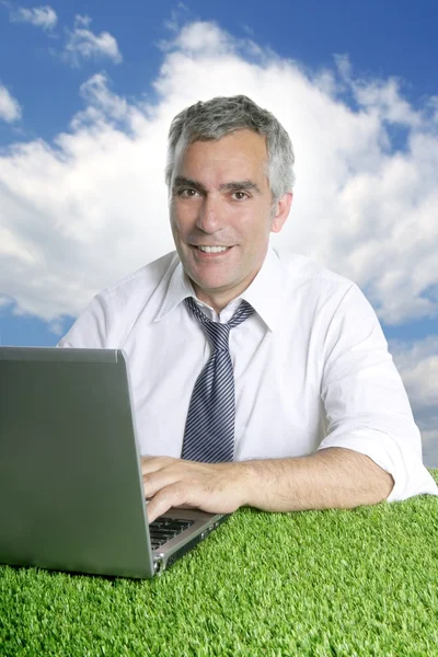 Empresário sênior trabalhar grama verde céu azul — Fotografia de Stock