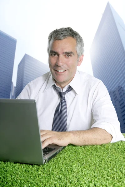 Senior business man green grass city buildings —  Fotos de Stock