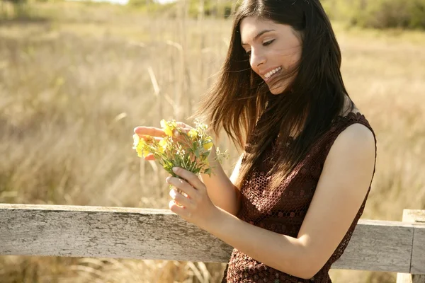 Vacker kvinna i gyllene utomhus, gul blomma — Stockfoto