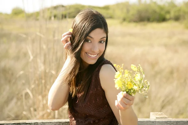 Mooie vrouw in gouden outdoor, gele bloem — Stockfoto