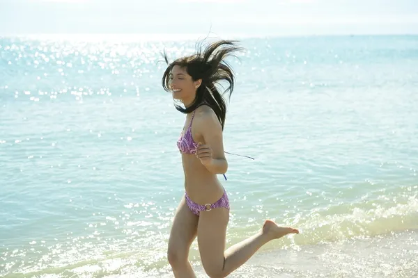 Hermosa mujer corriendo en bikini en la playa — Foto de Stock