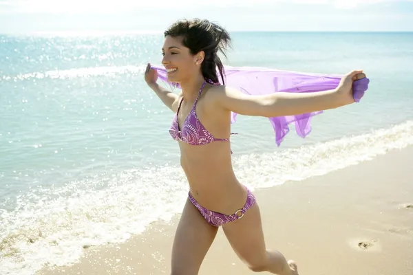 Schöne Frau läuft im Bikini am Strand — Stockfoto