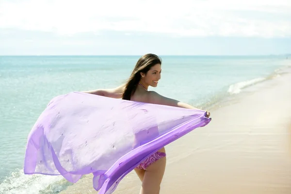 Krásná žena, běží v plavkách na pláži — Stock fotografie