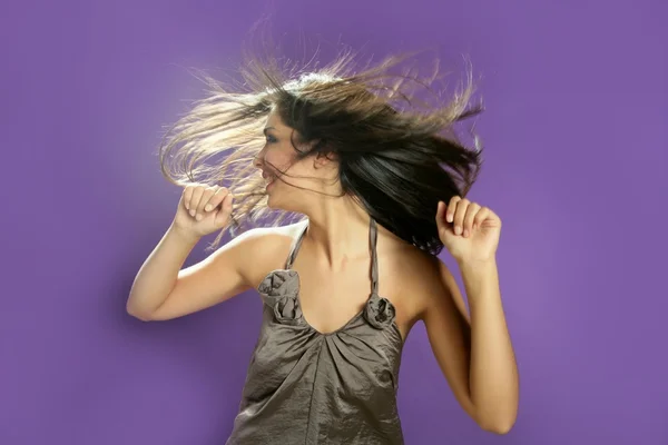 Брюнетка танцует в студии на фиолетовом фоне — стоковое фото