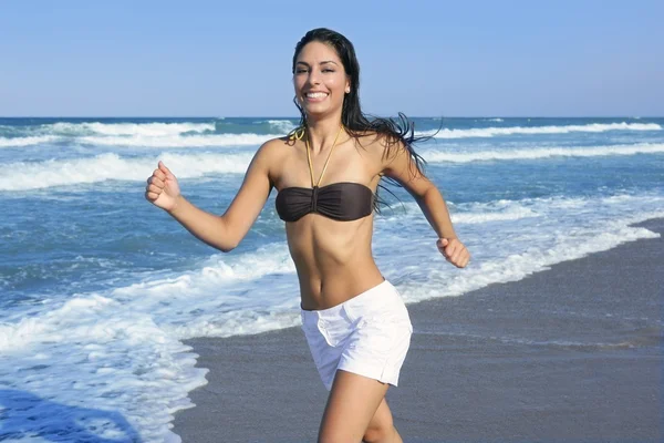 Mooie zomerse brunette meisje springen op het strand — Stockfoto