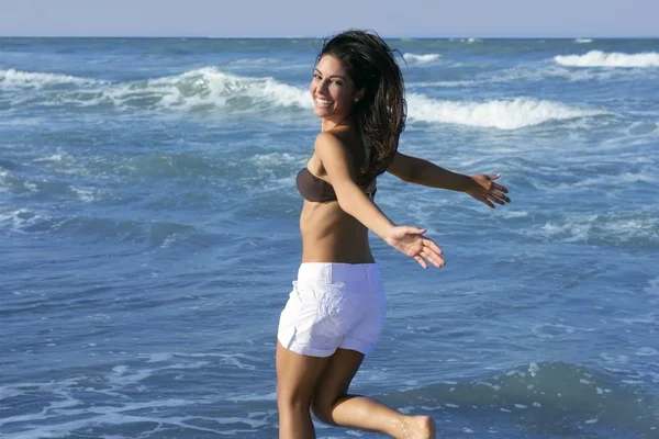Beautiful summer brunette girl jumping on the beach — Stock Photo, Image